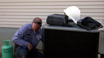 Technician checking on an AC unit