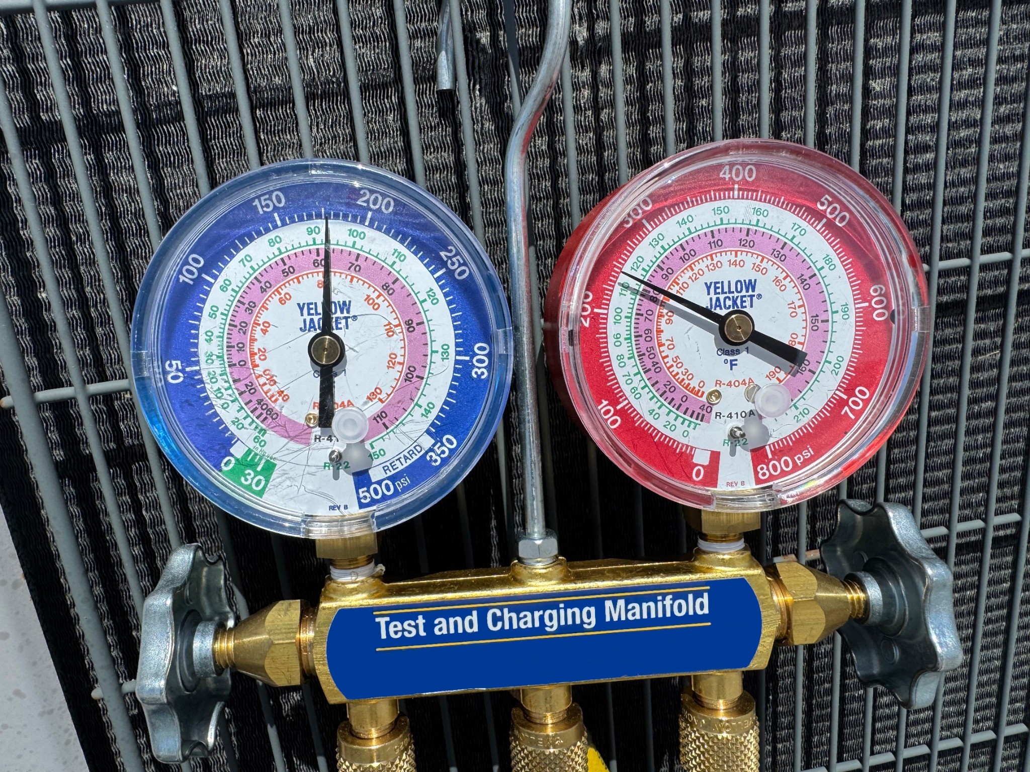 Refrigerant manifold gauges checking pressure during AC maintenance