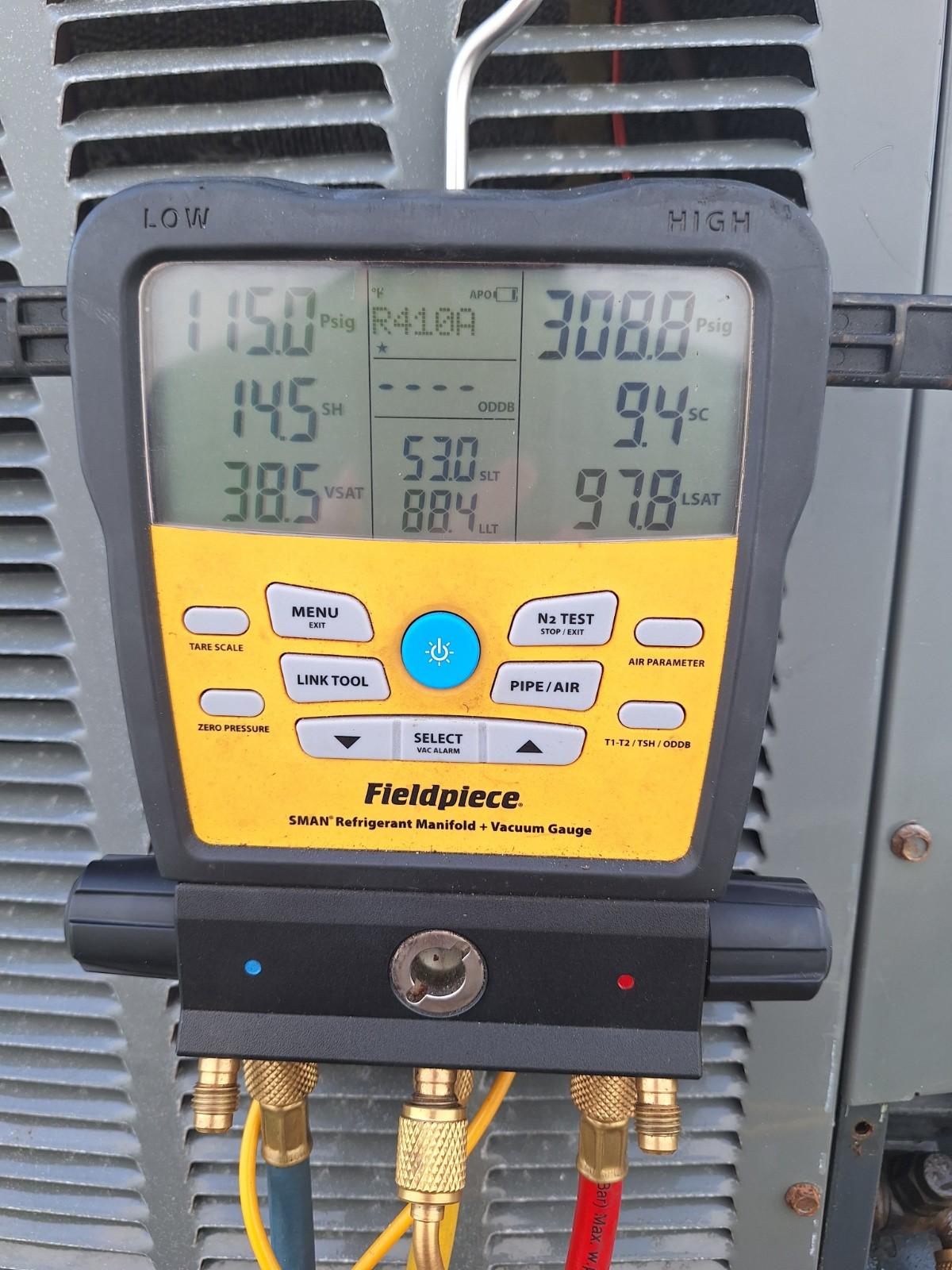 Digital refrigerant gauge measuring pressure on an air conditioner