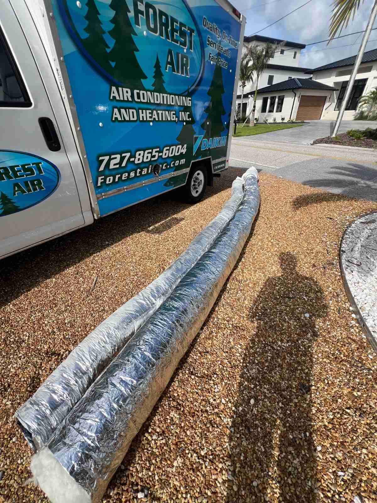 Old flex duct removed during a duct repair, beside a Forest Air service van