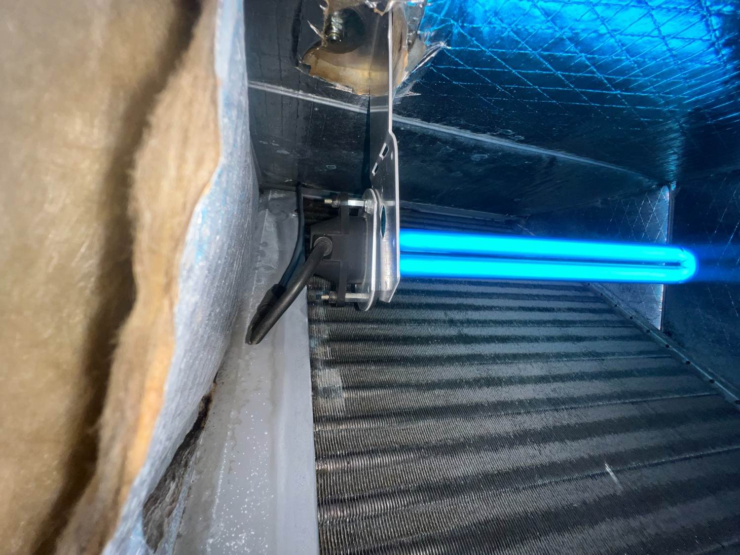 UV germicidal light glowing inside an air handler to reduce mold and bacteria